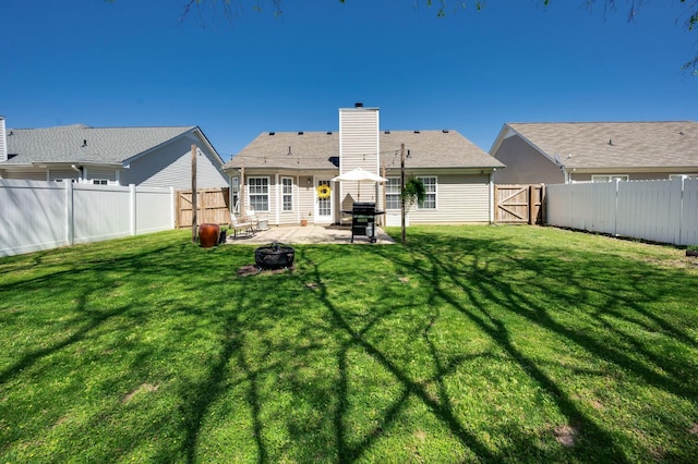 back of house featuring a patio area, a chimney, and an outdoor fire pit