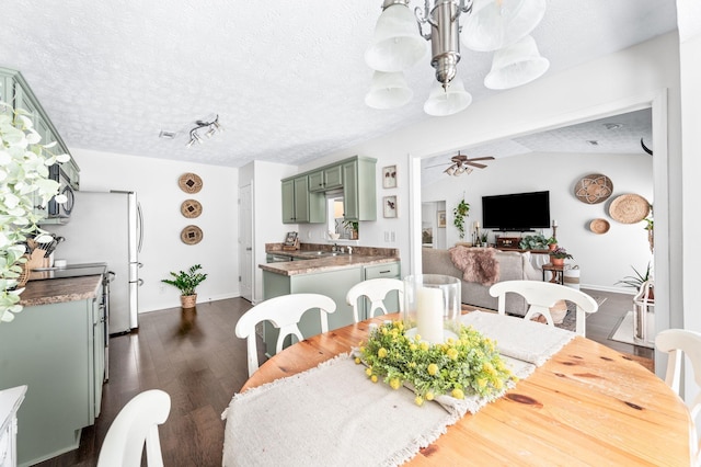 dining room with a chandelier, dark wood-type flooring, a textured ceiling, a ceiling fan, and baseboards