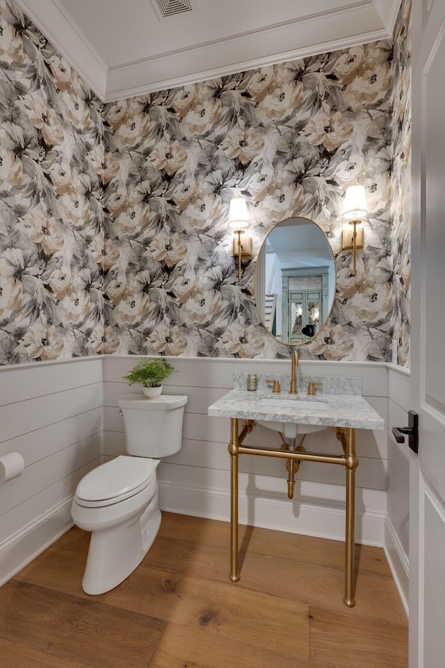 622 Stonewater Blvd, Franklin, TN 37064 - half bathroom featuring wallpapered walls, toilet, ornamental molding, wood finished floors, and a wainscoted wall