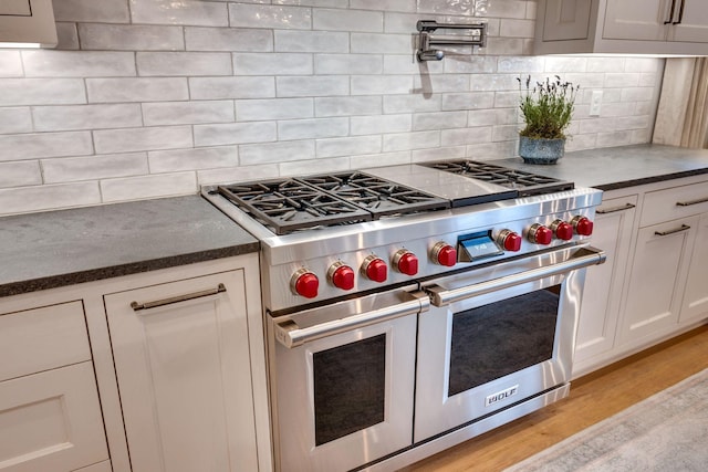 622 Stonewater Blvd, Franklin, TN 37064 - kitchen with double oven range, tasteful backsplash, light wood-type flooring, and white cabinets