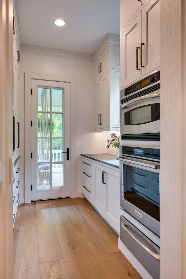 622 Stonewater Blvd, Franklin, TN 37064 - kitchen with a warming drawer, stainless steel double oven, light wood-type flooring, white cabinetry, and recessed lighting