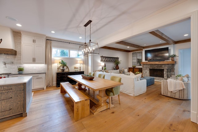 622 Stonewater Blvd, Franklin, TN 37064 - dining space with light wood-style floors, beam ceiling, a stone fireplace, a chandelier, and recessed lighting