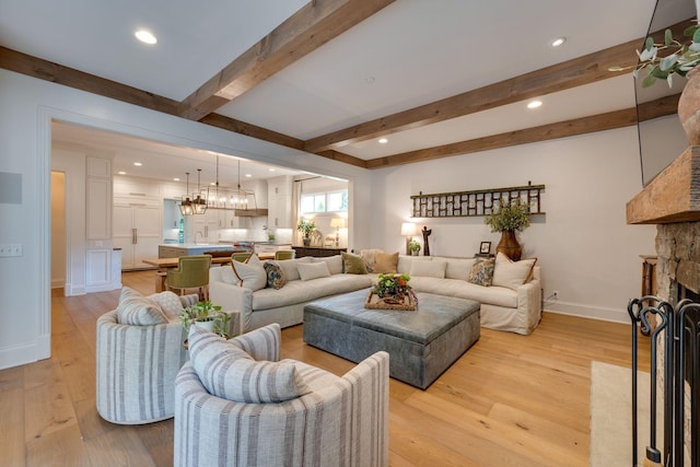622 Stonewater Blvd, Franklin, TN 37064 - living room with a stone fireplace, light wood finished floors, beam ceiling, a chandelier, and recessed lighting