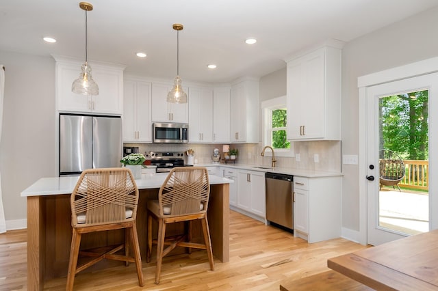 4345 S Garrett Rd, Springfield, TN 37172 - kitchen featuring stainless steel appliances, light countertops, a kitchen island, tasteful backsplash, and white cabinetry