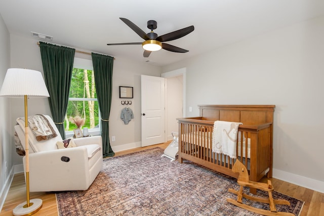 4345 S Garrett Rd, Springfield, TN 37172 - bedroom with wood finished floors, baseboards, a crib, and a ceiling fan