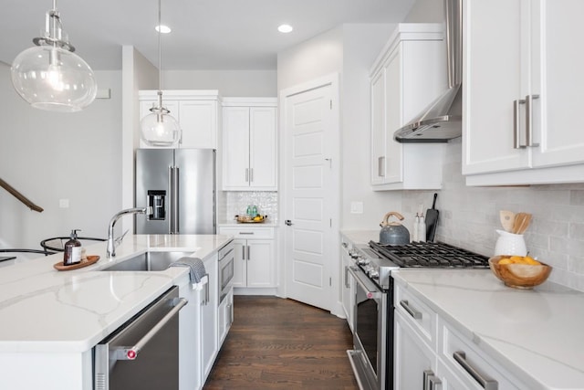 kitchen featuring high end appliances, a sink, dark wood-type flooring, decorative light fixtures, and white cabinets