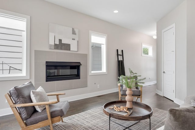 living room featuring dark wood finished floors, a tiled fireplace, baseboards, and recessed lighting