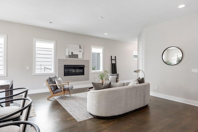 living room featuring dark wood finished floors, recessed lighting, baseboards, and a glass covered fireplace