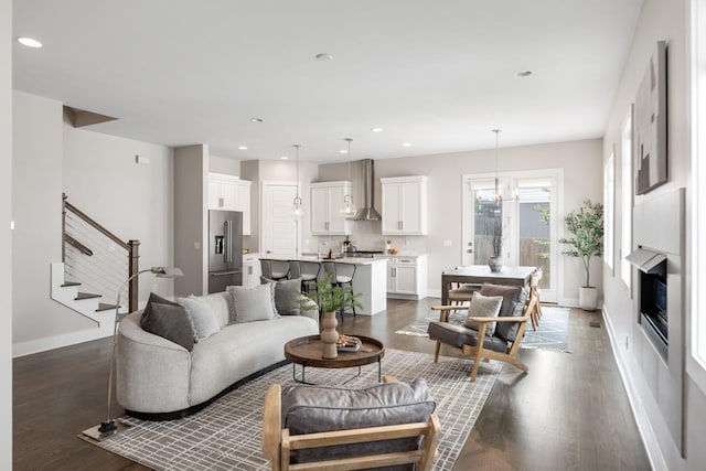 living area featuring dark wood-style flooring, stairs, baseboards, and recessed lighting