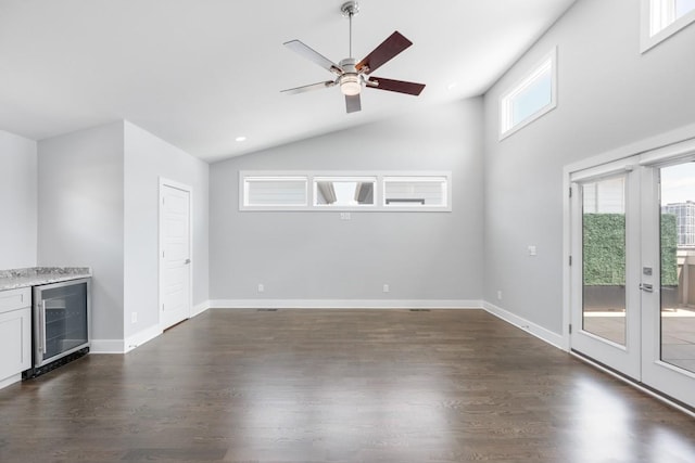 unfurnished living room featuring wine cooler, dark wood-type flooring, ceiling fan, french doors, and high vaulted ceiling