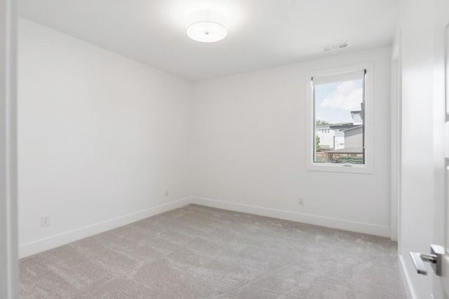 unfurnished room featuring light colored carpet and baseboards