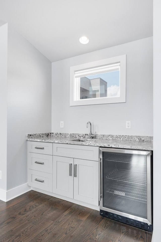 indoor wet bar featuring wine cooler, dark wood-type flooring, baseboards, and recessed lighting