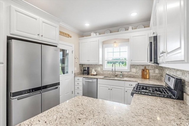 401 Hancock Ln, Tullahoma, TN 37388 - kitchen with stainless steel appliances, a sink, decorative backsplash, white cabinetry, and light stone countertops