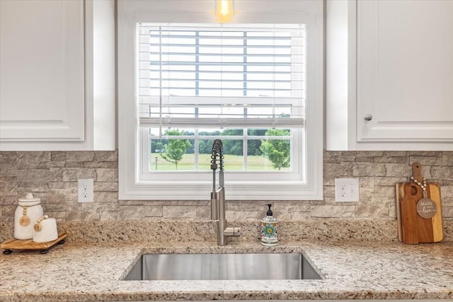 401 Hancock Ln, Tullahoma, TN 37388 - kitchen featuring a sink, white cabinetry, tasteful backsplash, and light stone counters