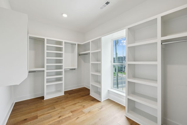 walk in closet with wood finished floors