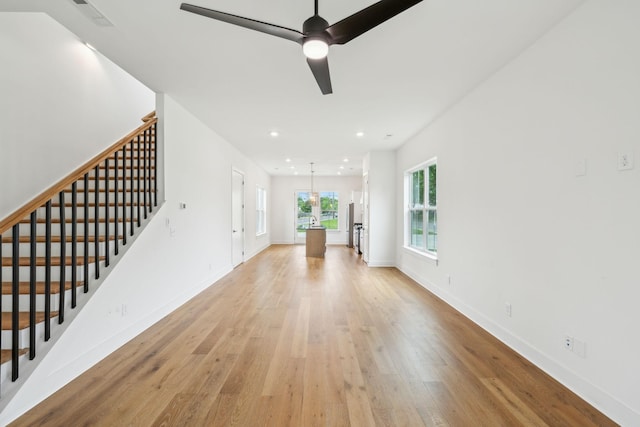 unfurnished living room with light wood-style floors, stairs, recessed lighting, baseboards, and a ceiling fan