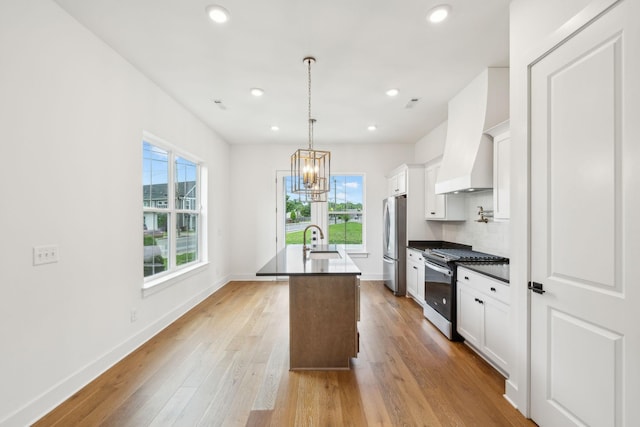 kitchen with appliances with stainless steel finishes, a sink, a chandelier, healthy amount of natural light, and recessed lighting
