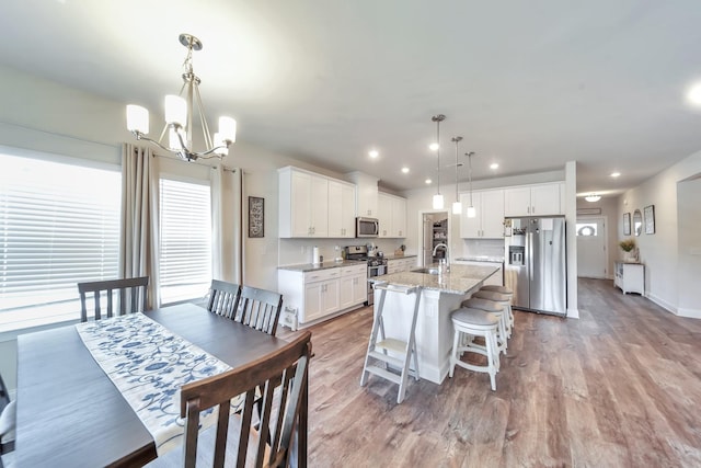 4022 Arrowleaf Ln, Antioch, TN 37013 - kitchen featuring stainless steel appliances, a chandelier, a center island with sink, white cabinetry, and light stone countertops