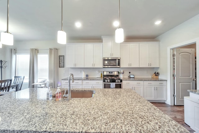 4022 Arrowleaf Ln, Antioch, TN 37013 - kitchen with stainless steel appliances, a sink, white cabinets, light stone countertops, and recessed lighting