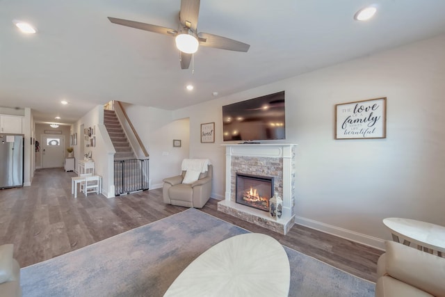 4022 Arrowleaf Ln, Antioch, TN 37013 - living area featuring wood finished floors, baseboards, a stone fireplace, a ceiling fan, and stairway
