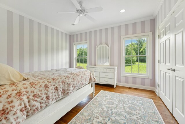 219 Dale Ln, Hilham, TN 38568 - bedroom featuring multiple windows, crown molding, wood finished floors, wallpapered walls, and baseboards