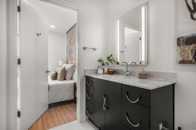 bathroom with vanity, ensuite bathroom, and wood finished floors