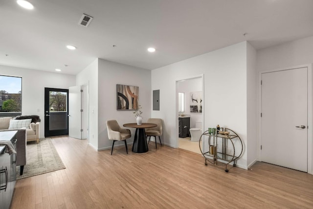 dining area with light wood-style flooring, recessed lighting, electric panel, and baseboards