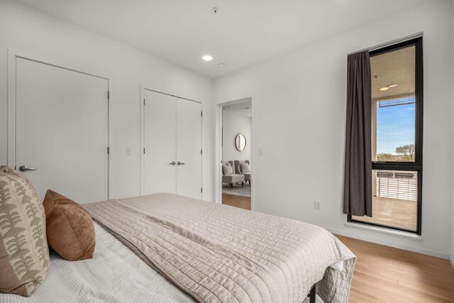 bedroom with light wood-style flooring, a closet, baseboards, and recessed lighting