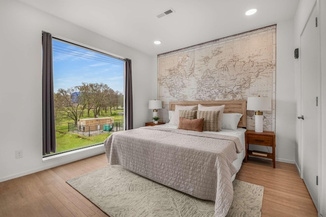 bedroom with recessed lighting, wood finished floors, and baseboards