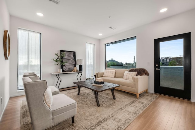 living room with light wood-type flooring, healthy amount of natural light, and recessed lighting