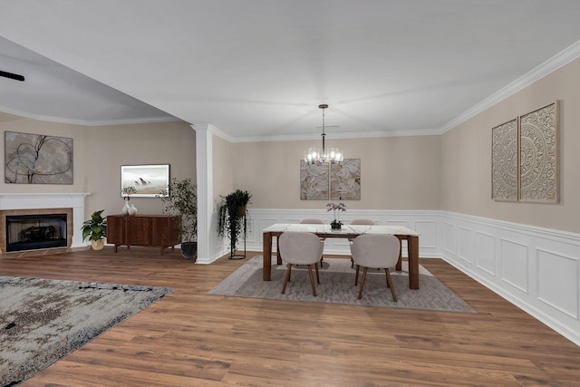 3319 Mershon Dr, Murfreesboro, TN 37128 - dining space featuring ornamental molding, wood finished floors, a tiled fireplace, a wainscoted wall, and a chandelier