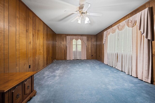 915 Taylor Cir, Burns, TN 37029 - spare room featuring wooden walls, carpet flooring, and ceiling fan