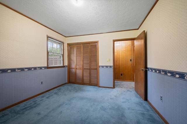 915 Taylor Cir, Burns, TN 37029 - unfurnished bedroom with ornamental molding, a closet, wallpapered walls, a textured ceiling, and a wainscoted wall