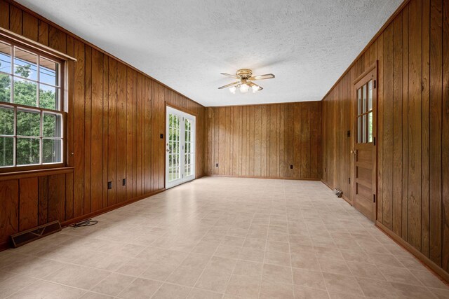 915 Taylor Cir, Burns, TN 37029 - unfurnished room featuring healthy amount of natural light, a textured ceiling, wooden walls, a ceiling fan, and baseboards