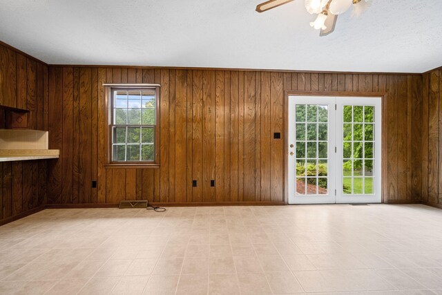 915 Taylor Cir, Burns, TN 37029 - unfurnished dining area with baseboards, wooden walls, a ceiling fan, and a textured ceiling