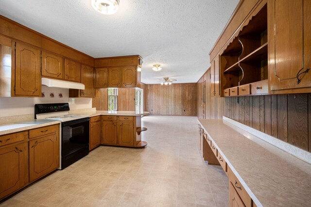 915 Taylor Cir, Burns, TN 37029 - kitchen with range with electric stovetop, under cabinet range hood, a peninsula, light countertops, and brown cabinets