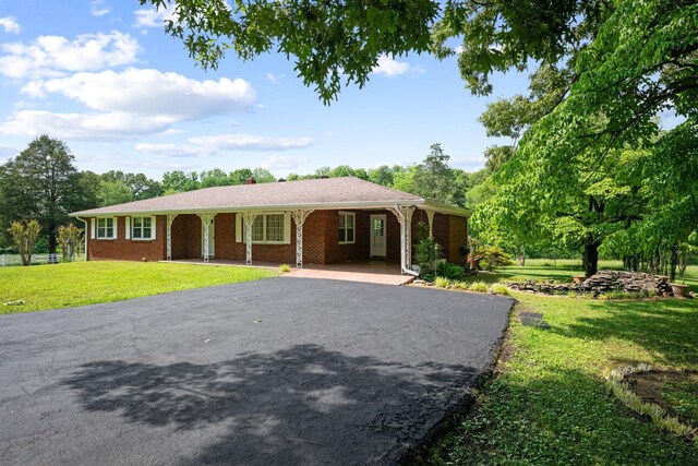 915 Taylor Cir, Burns, TN 37029 - ranch-style house featuring driveway, a front yard, and brick siding