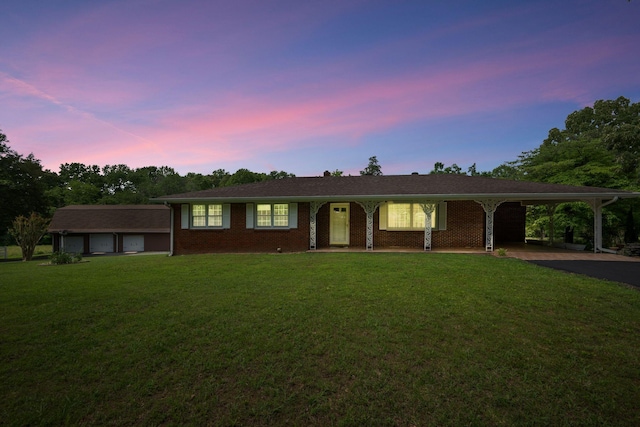915 Taylor Cir, Burns, TN 37029 - ranch-style home with asphalt driveway, a lawn, an attached carport, and brick siding