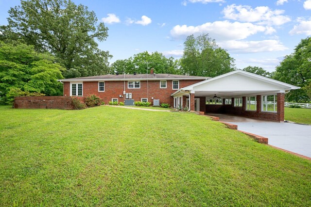 915 Taylor Cir, Burns, TN 37029 - view of front of house with a front lawn, driveway, brick siding, a ceiling fan, and a chimney