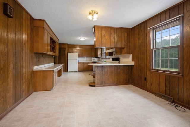 915 Taylor Cir, Burns, TN 37029 - kitchen with white appliances, open shelves, light countertops, wood walls, and brown cabinetry