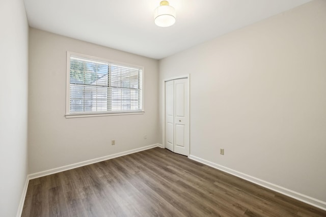 unfurnished room featuring dark wood finished floors and baseboards
