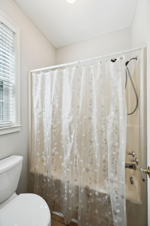 bathroom featuring plenty of natural light, toilet, and a shower with shower curtain