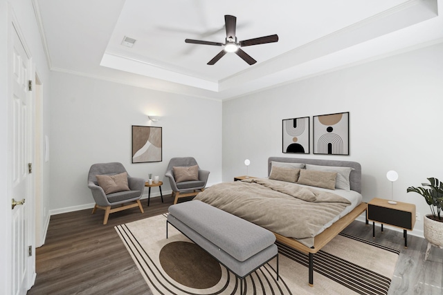 bedroom with a raised ceiling, wood finished floors, baseboards, a ceiling fan, and ornamental molding