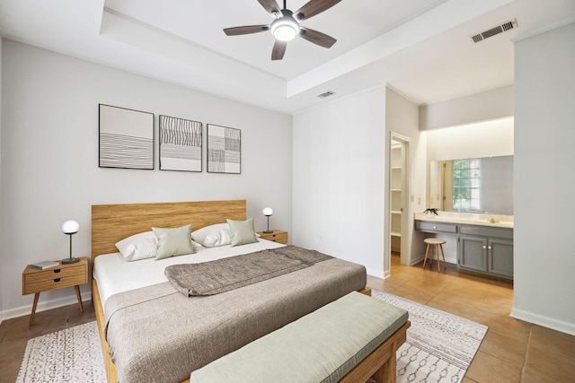 bedroom with light tile patterned floors, baseboards, and a tray ceiling