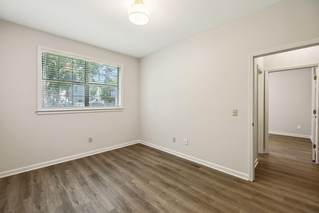 empty room featuring dark wood-style floors and baseboards