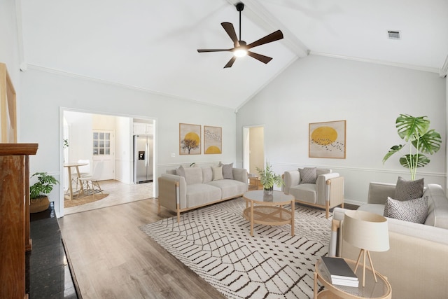 living room with ceiling fan, light wood finished floors, beamed ceiling, and high vaulted ceiling