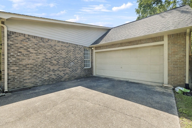 garage featuring asphalt driveway