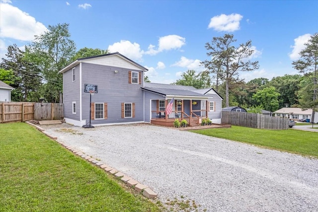 rear view of property featuring driveway and covered porch