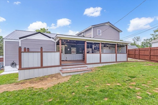 rear view of property featuring a sunroom and metal roof