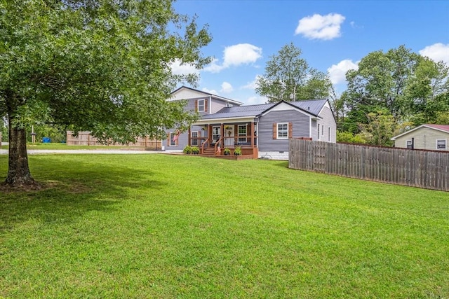 rear view of house featuring a porch and metal roof